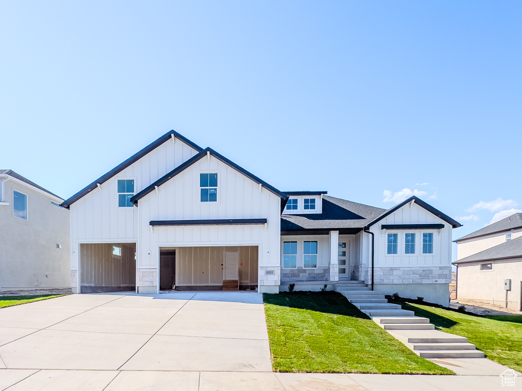 View of front facade with a garage and a front lawn