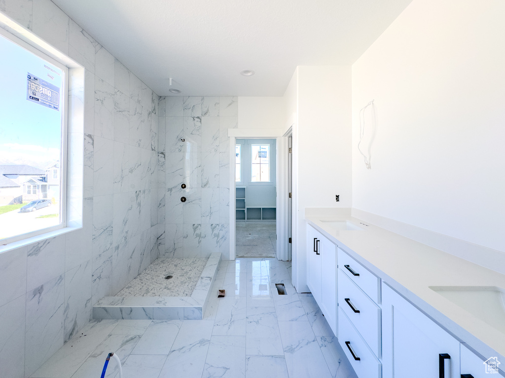 Bathroom with vanity, plenty of natural light, and a tile shower