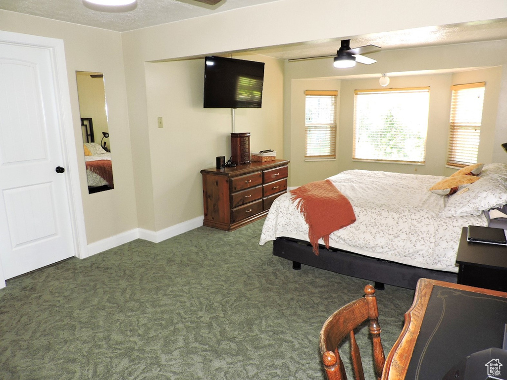 Carpeted bedroom featuring a textured ceiling and ceiling fan