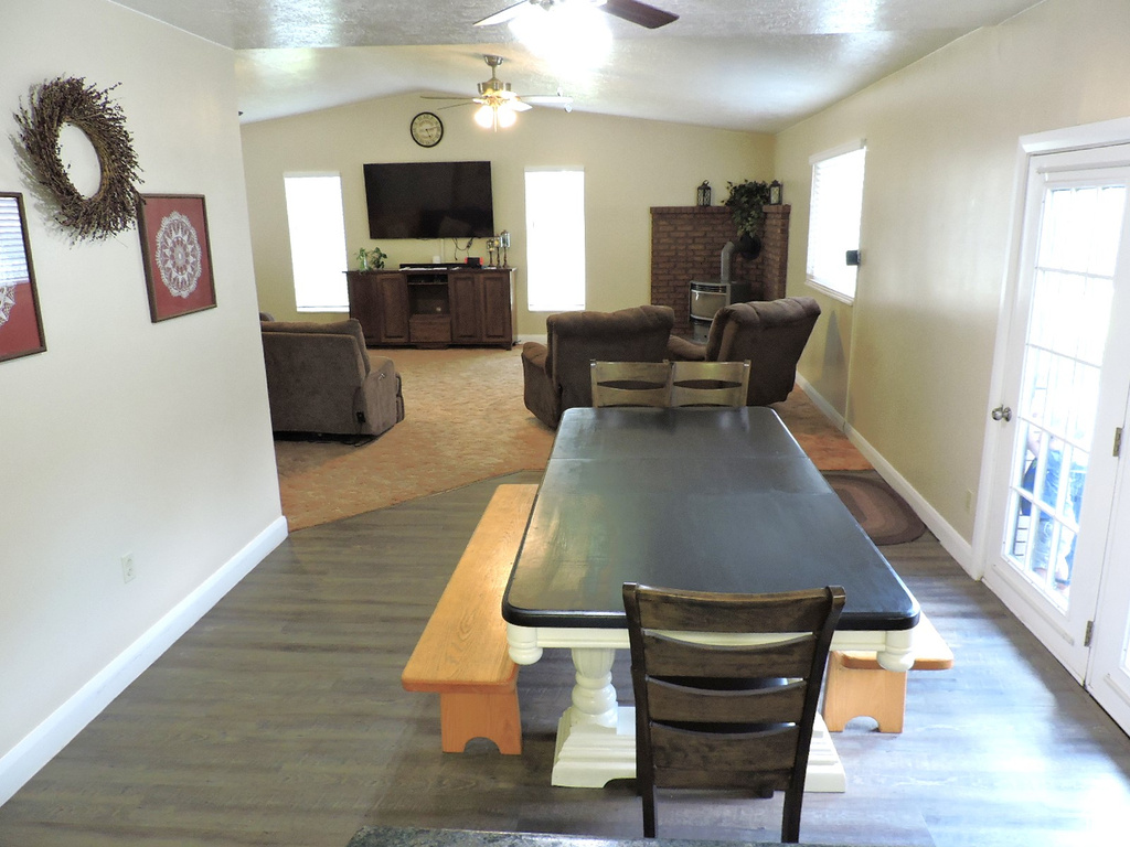 Dining space with lofted ceiling, dark hardwood / wood-style flooring, ceiling fan, and a wealth of natural light