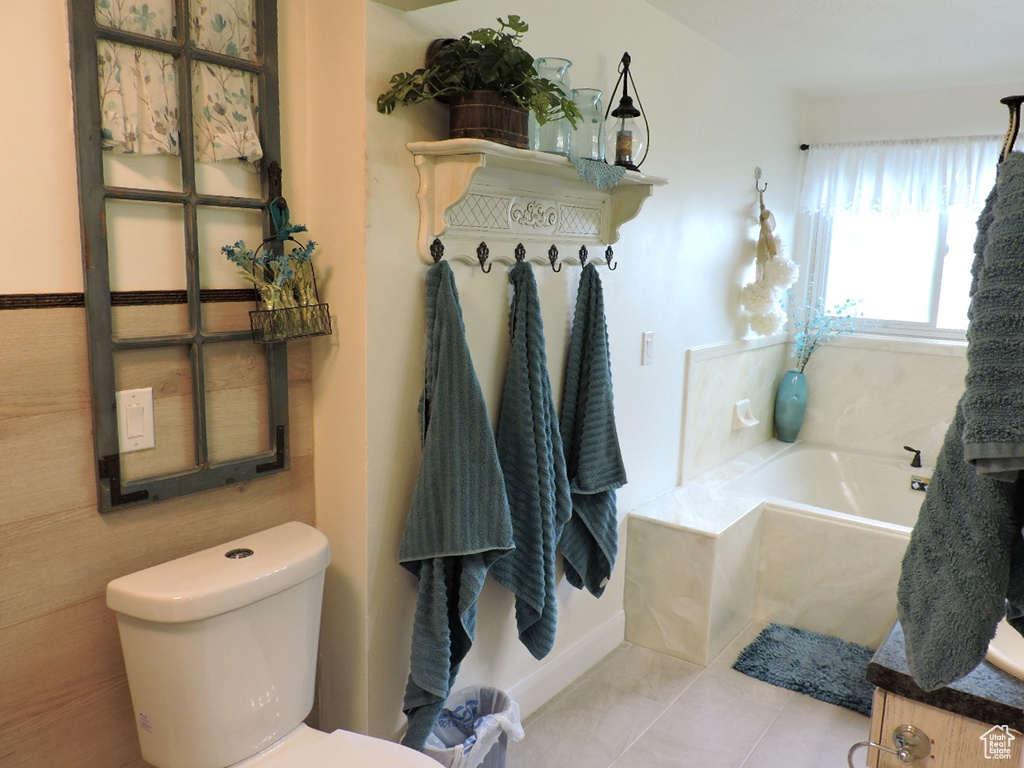 Bathroom with vanity, toilet, tile patterned floors, and a bathing tub