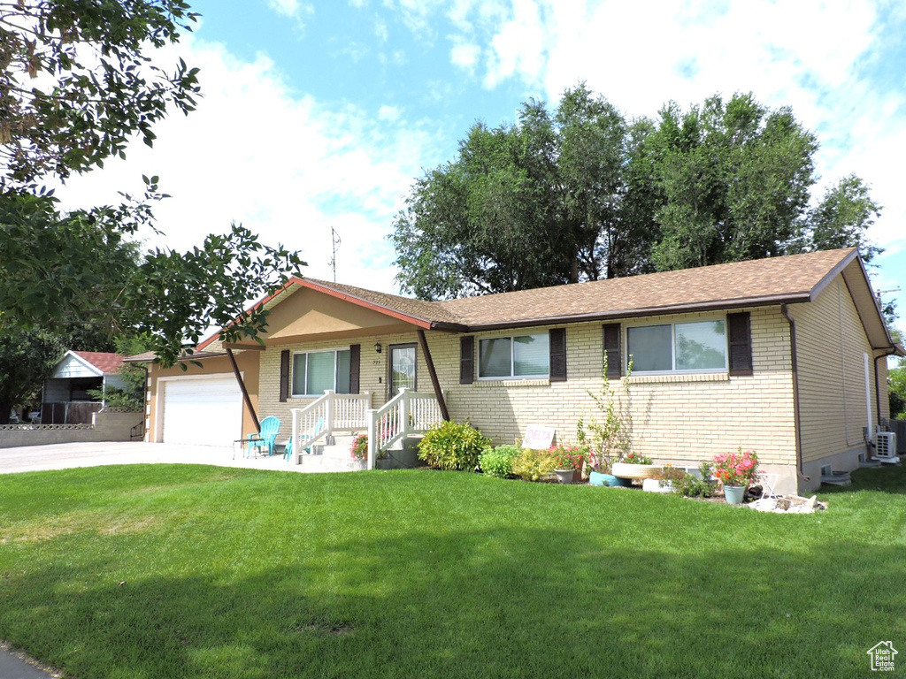 Ranch-style house with a garage, a front yard, and central AC unit