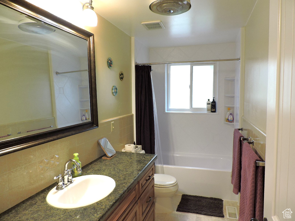 Full bathroom featuring shower / tub combo, tasteful backsplash, toilet, tile patterned floors, and vanity