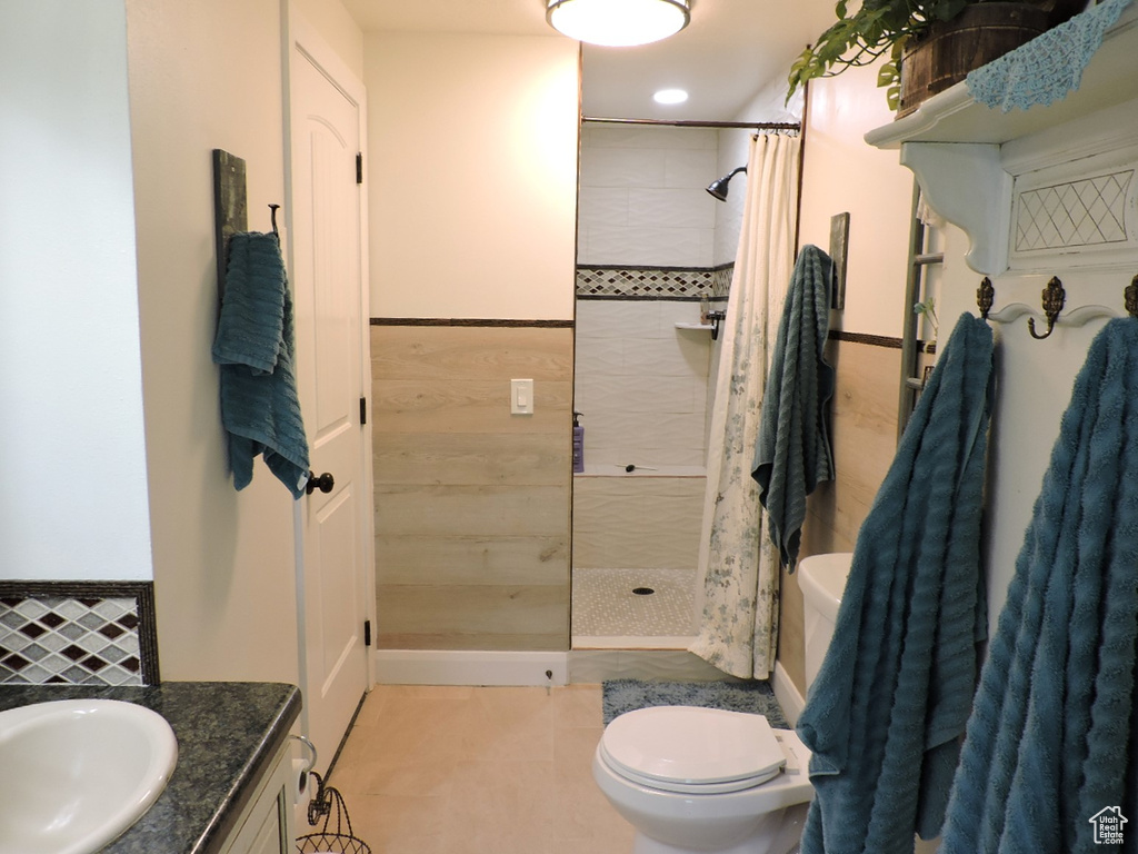 Bathroom with curtained shower, vanity, tile patterned flooring, and toilet