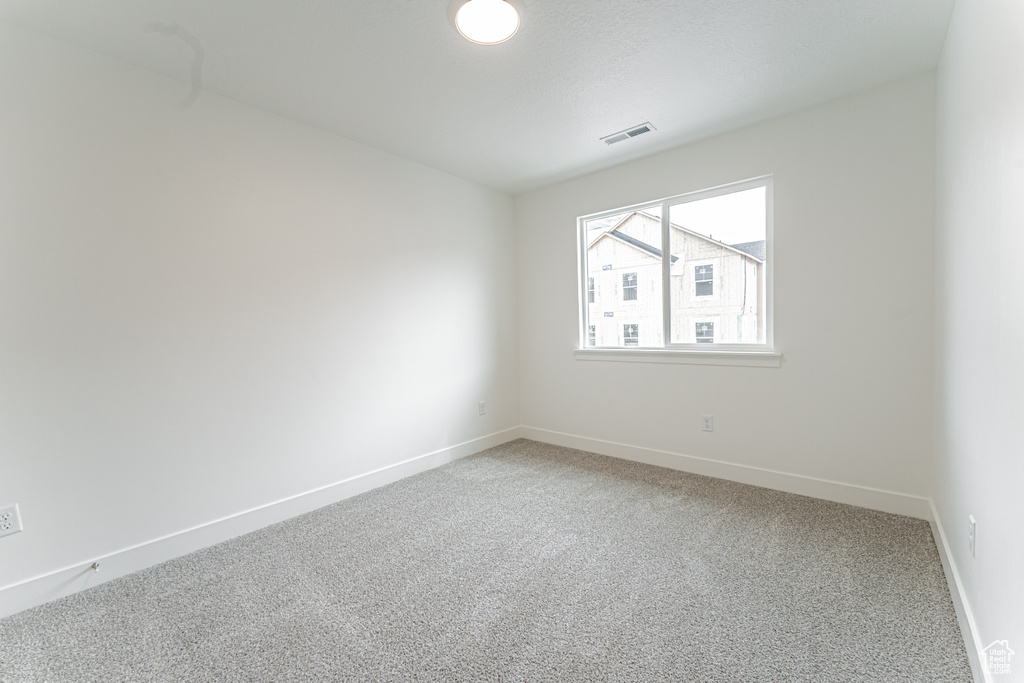 Unfurnished room with light colored carpet, visible vents, and baseboards