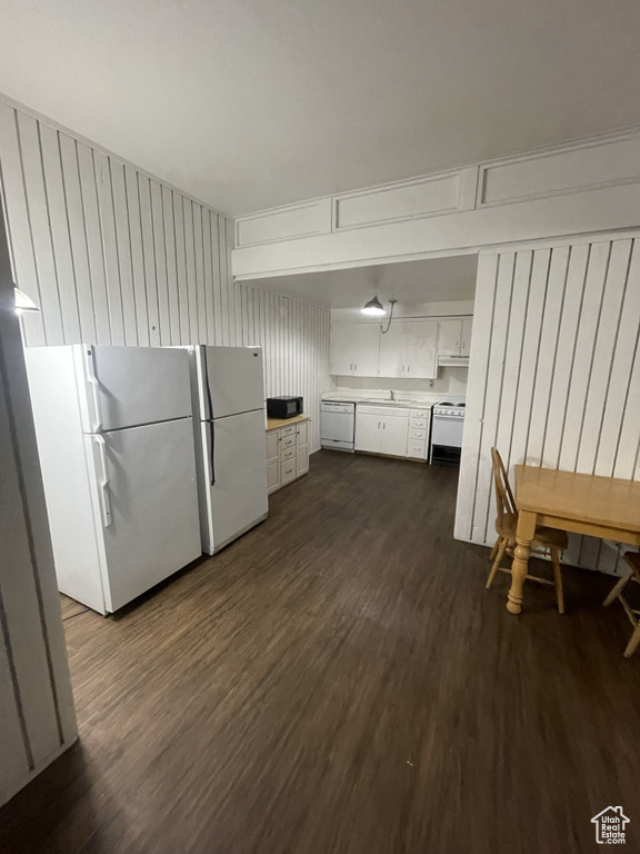 Clothes washing area with dark hardwood / wood-style floors