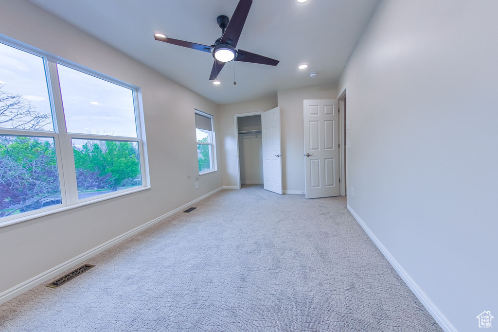 Unfurnished bedroom featuring light colored carpet and ceiling fan