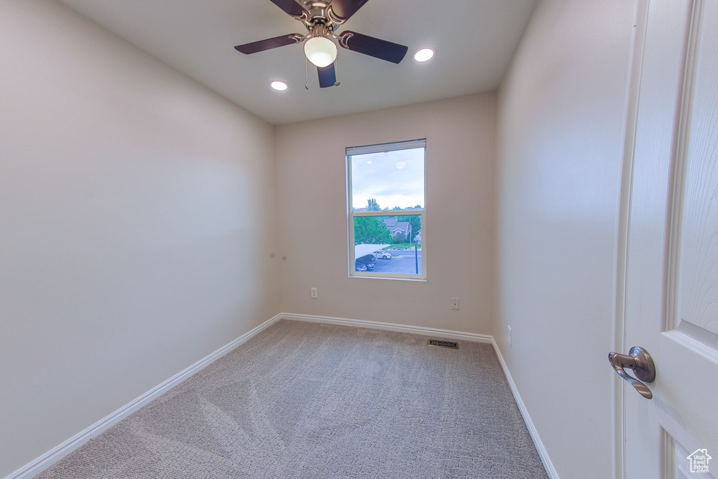 Carpeted spare room featuring ceiling fan