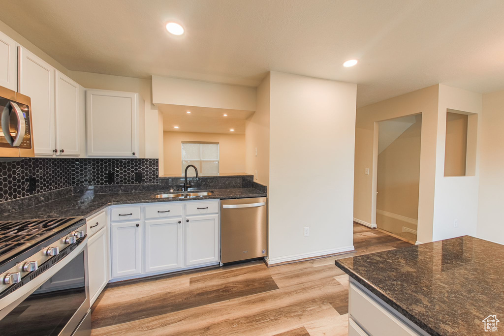 Kitchen featuring white cabinetry, stainless steel appliances, light hardwood / wood-style flooring, and sink