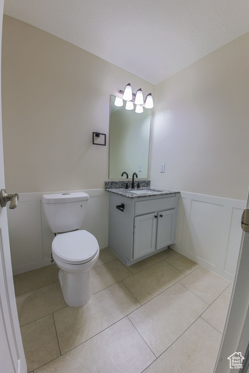 Bathroom featuring tile patterned flooring, toilet, and vanity