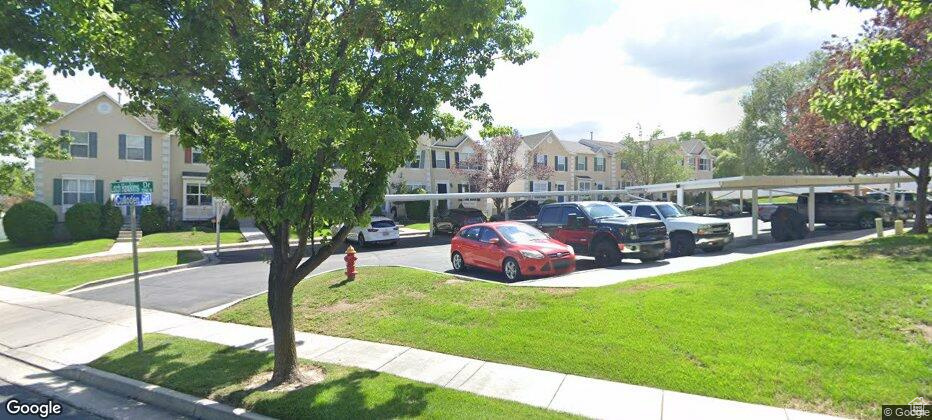 View of car parking featuring a lawn and a carport
