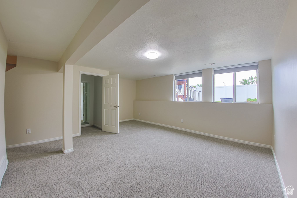 Unfurnished bedroom with a textured ceiling and light colored carpet