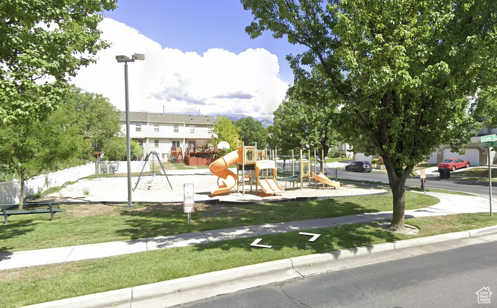 View of front of property with a front yard and a playground