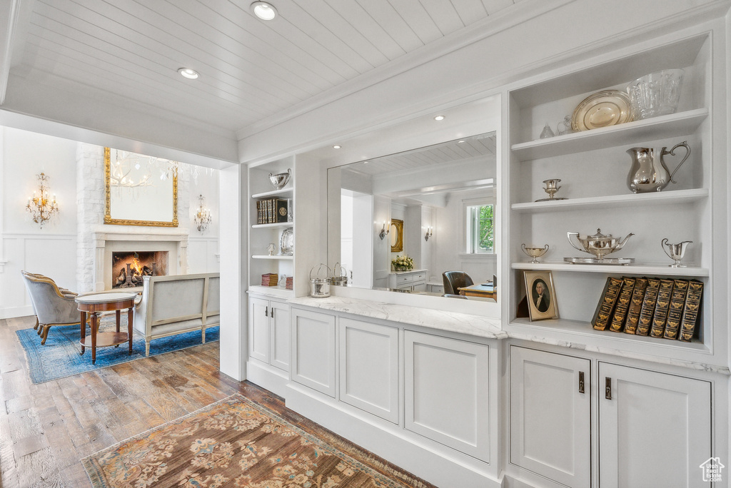 Interior space featuring wooden ceiling, light hardwood / wood-style flooring, a fireplace, and crown molding