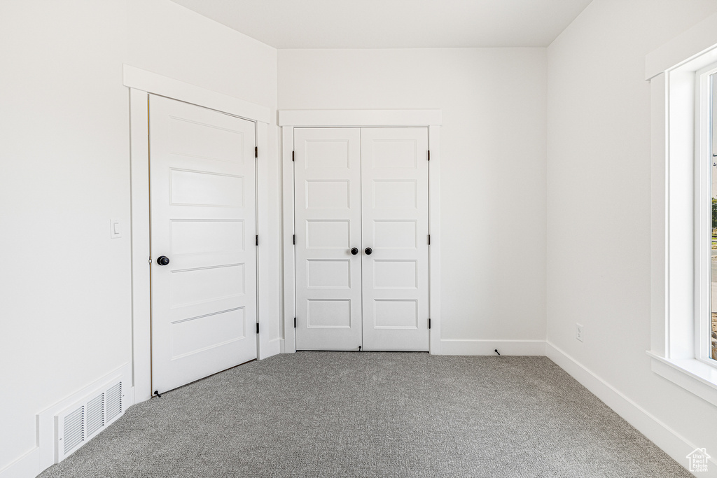 Unfurnished bedroom with carpet flooring and a closet