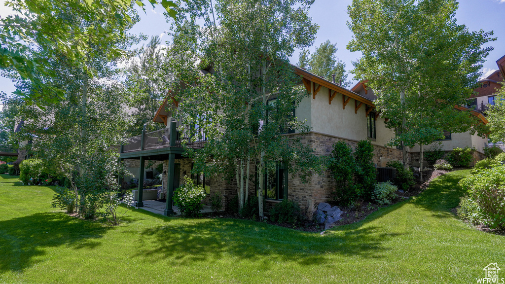 View of home\\\'s exterior featuring a balcony and a lawn