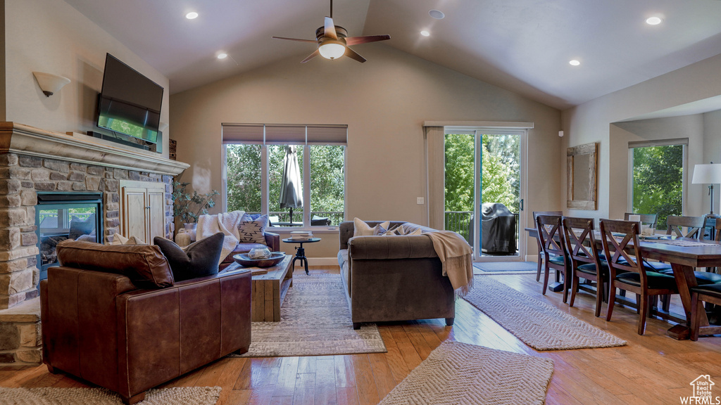 Living room with ceiling fan, a fireplace, and a wealth of natural light