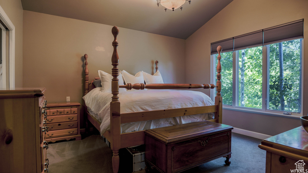 Bedroom featuring dark carpet and vaulted ceiling