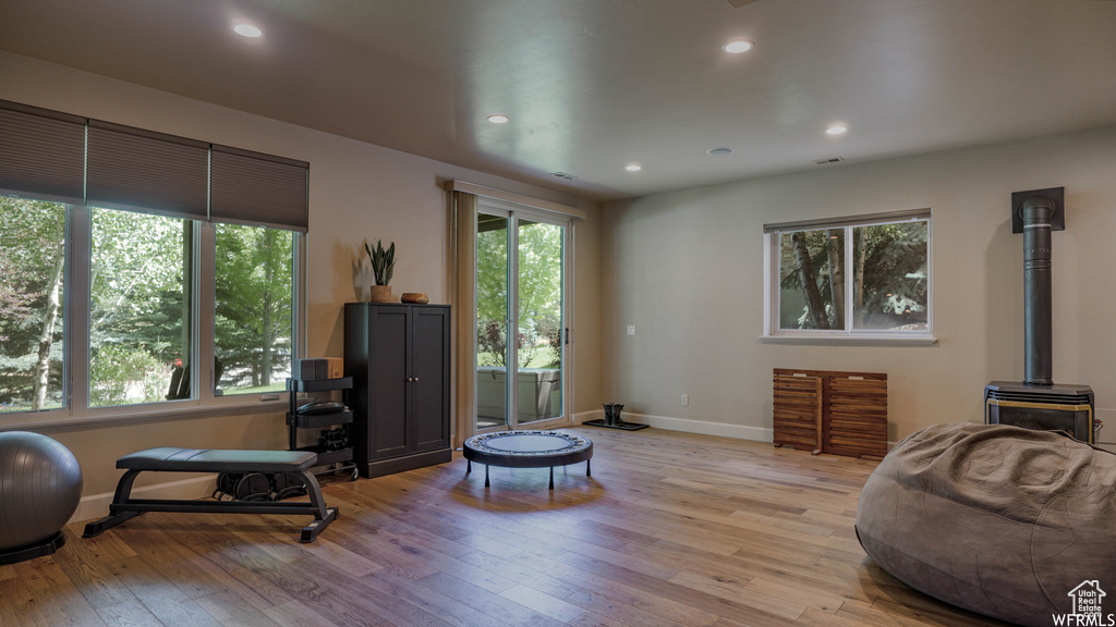 Living room with a wood stove and light hardwood / wood-style floors