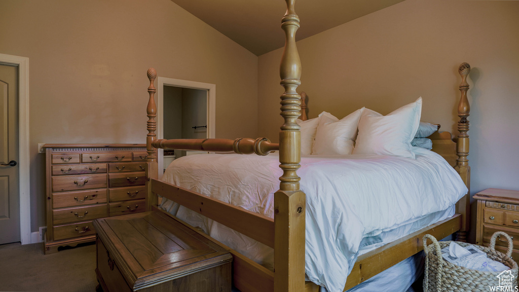 Bedroom with lofted ceiling and carpet flooring