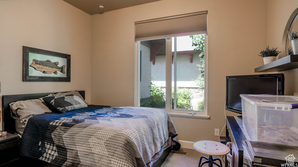 Bedroom featuring carpet and multiple windows