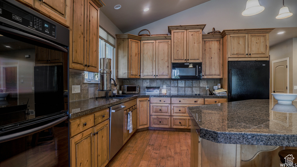 Kitchen featuring black appliances, backsplash, light hardwood / wood-style flooring, and vaulted ceiling