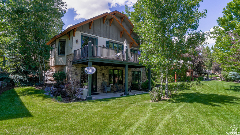 Rear view of house with a lawn and a patio area