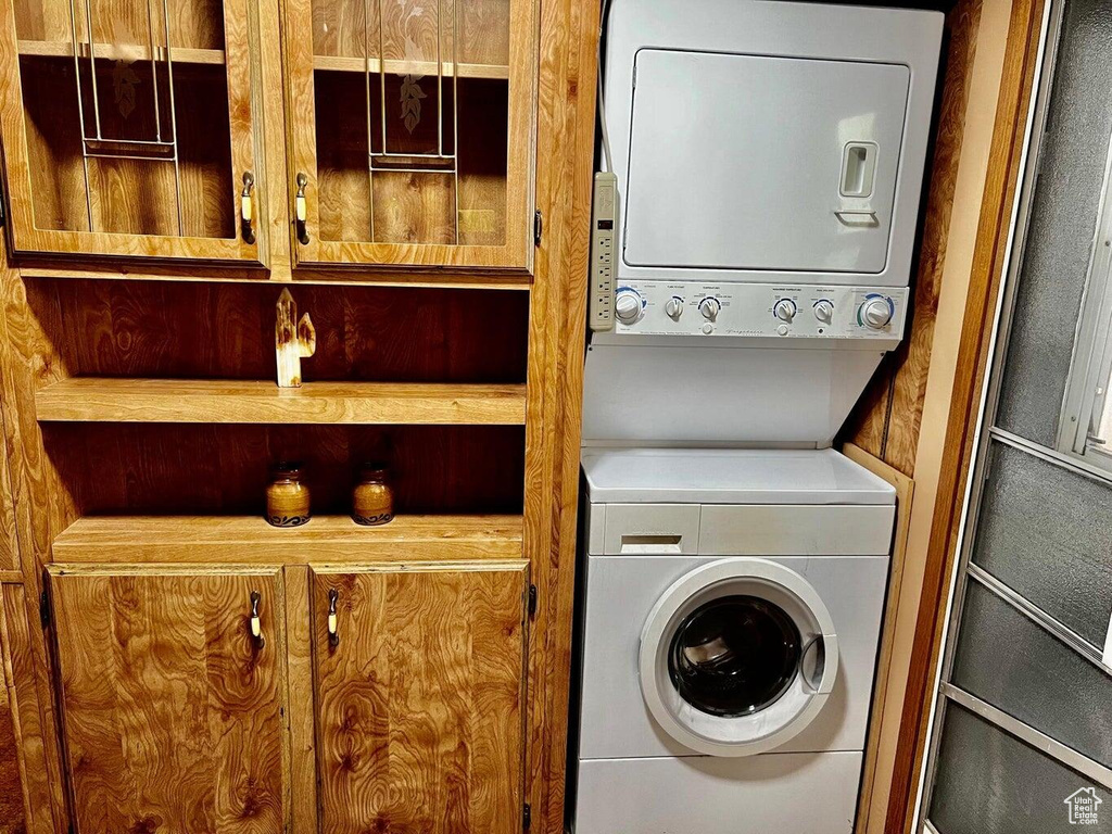 Laundry room with stacked washer and clothes dryer