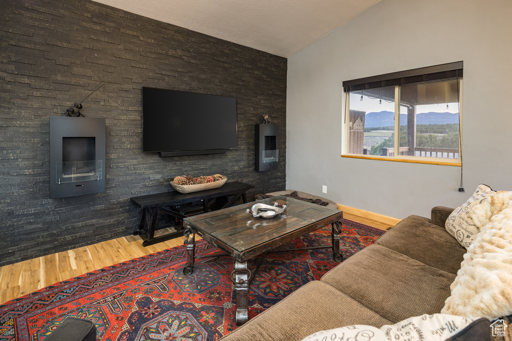 Living room with lofted ceiling and hardwood / wood-style floors