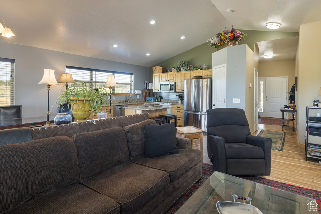 Living room featuring light hardwood / wood-style flooring, high vaulted ceiling, and plenty of natural light