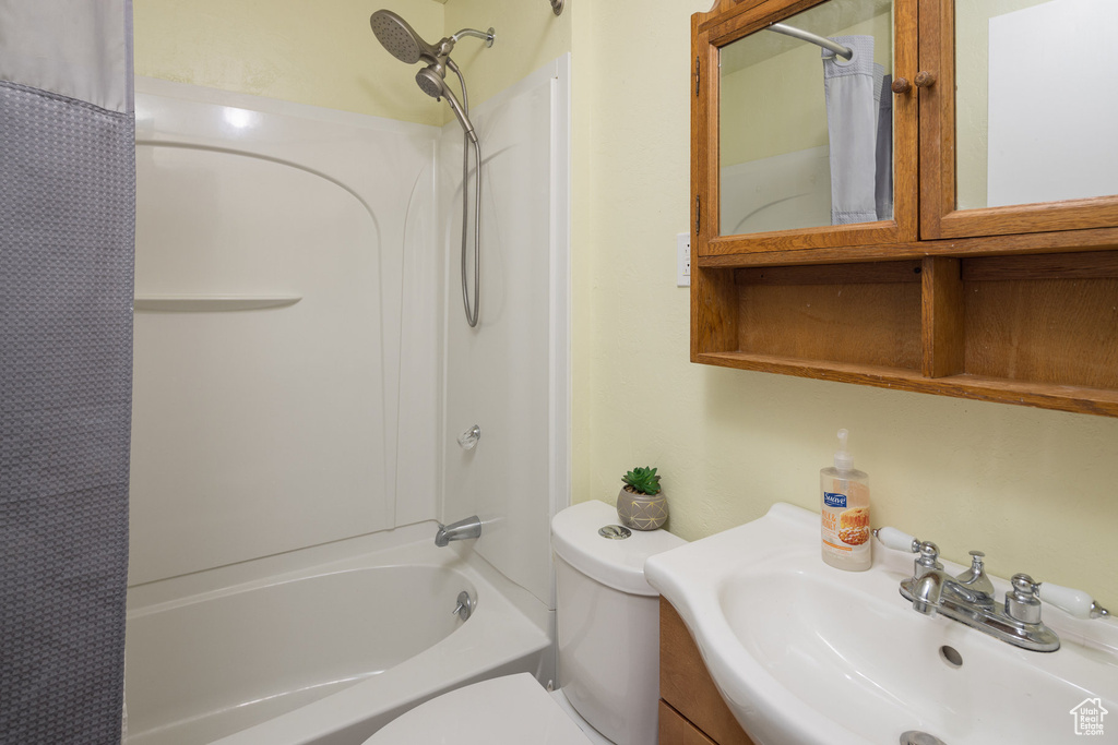 Full bathroom featuring vanity, shower / bathtub combination with curtain, and toilet