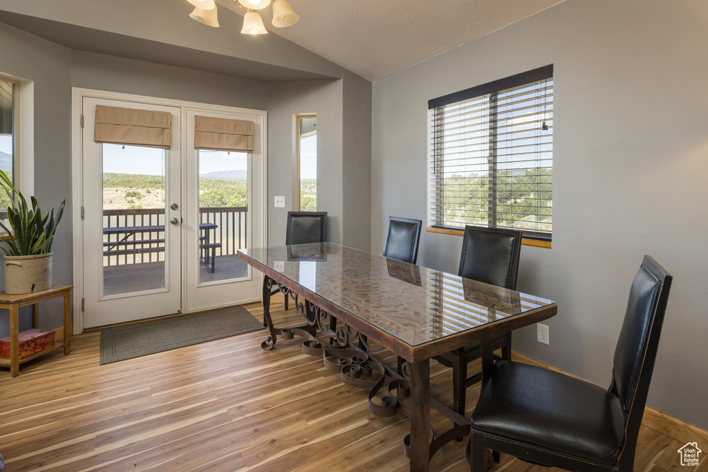 Dining area with vaulted ceiling, french doors, and hardwood / wood-style floors