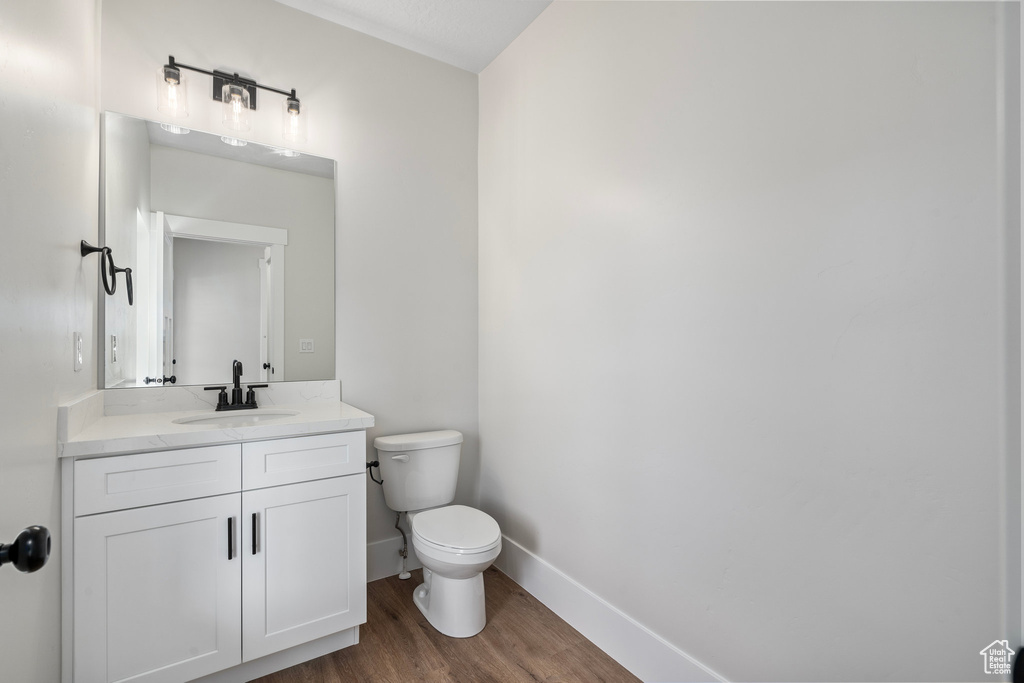 Bathroom featuring vanity, toilet, and hardwood / wood-style floors