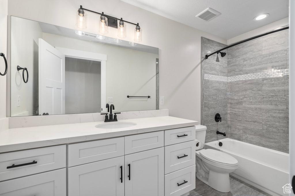 Full bathroom with tile patterned floors, vanity, toilet, and tiled shower / bath