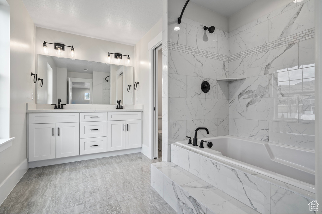 Bathroom with double sink vanity and tile patterned flooring