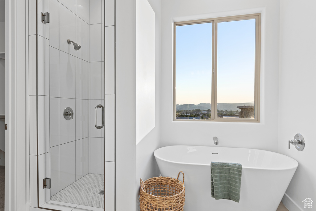 Full bath with healthy amount of natural light, a stall shower, and a freestanding tub