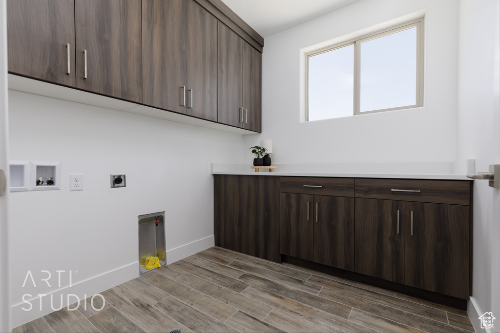 Laundry room with wood-type flooring, washer hookup, cabinets, and hookup for an electric dryer