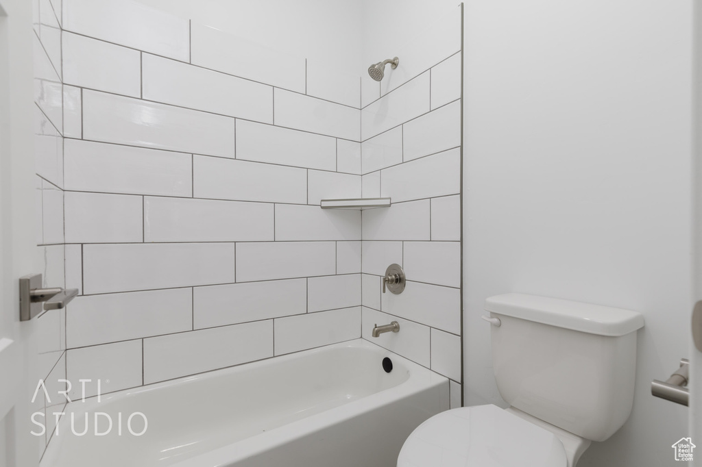 Bathroom featuring tiled shower / bath and toilet