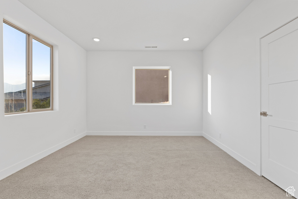 Unfurnished room with light colored carpet and recessed lighting