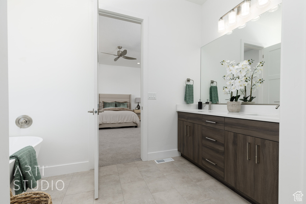 Bathroom featuring ceiling fan, vanity, and tile patterned flooring