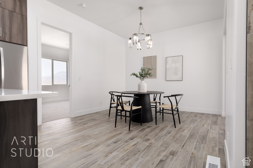 Dining area featuring light hardwood / wood-style flooring and a notable chandelier