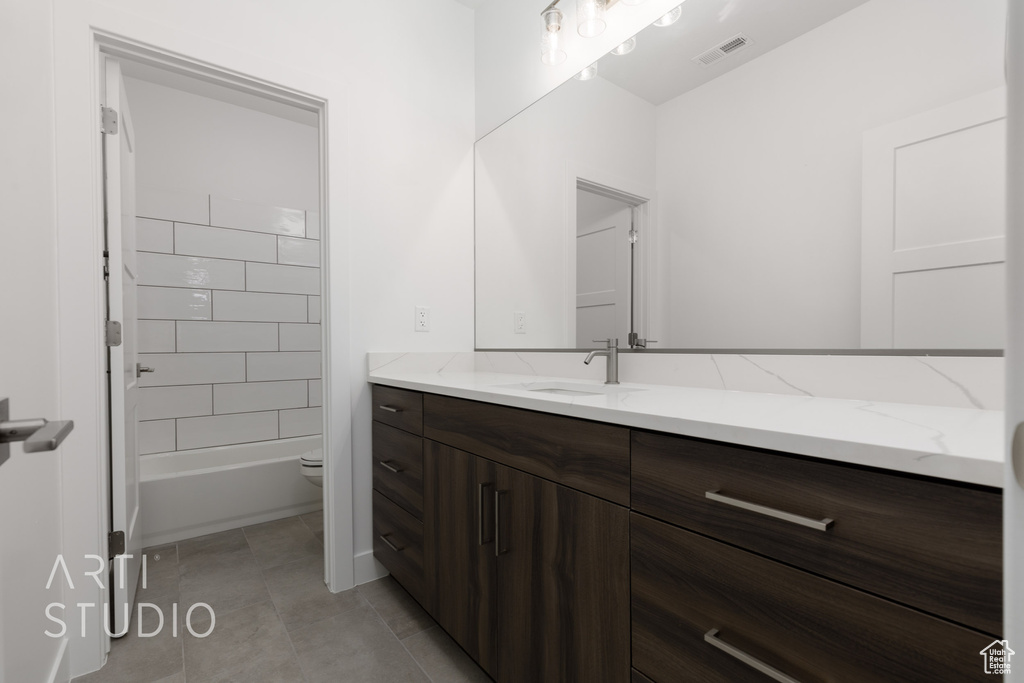 Bathroom featuring vanity, toilet, and tile patterned floors