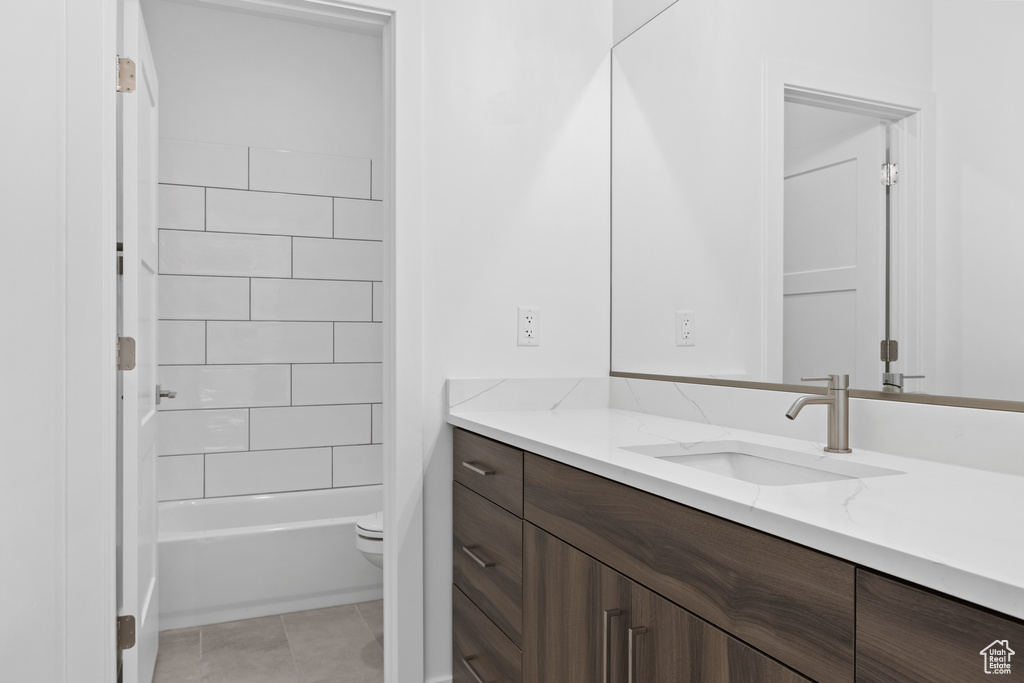 Bathroom with vanity, washtub / shower combination, and tile patterned floors