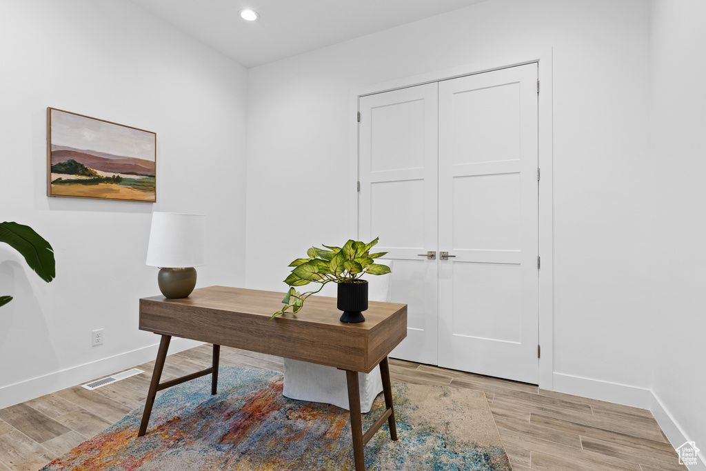 Office area featuring light wood-style flooring and recessed lighting