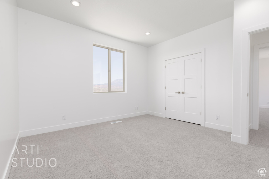 Unfurnished bedroom featuring light carpet