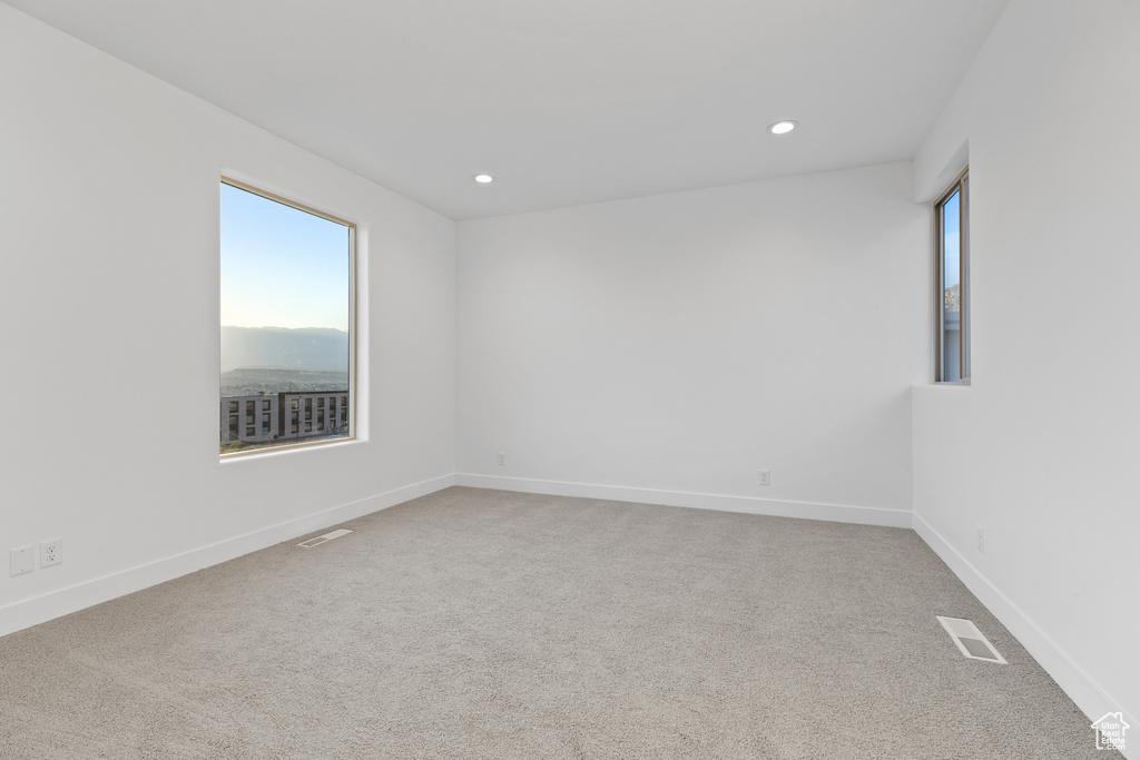 Spare room with healthy amount of natural light, carpet, and recessed lighting