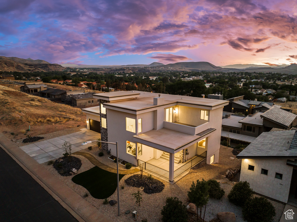 View of front of home with a mountain view, driveway, a garage, and stucco siding