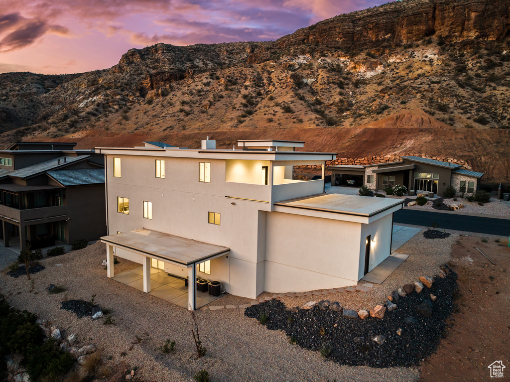 Back of house featuring a mountain view and stucco siding