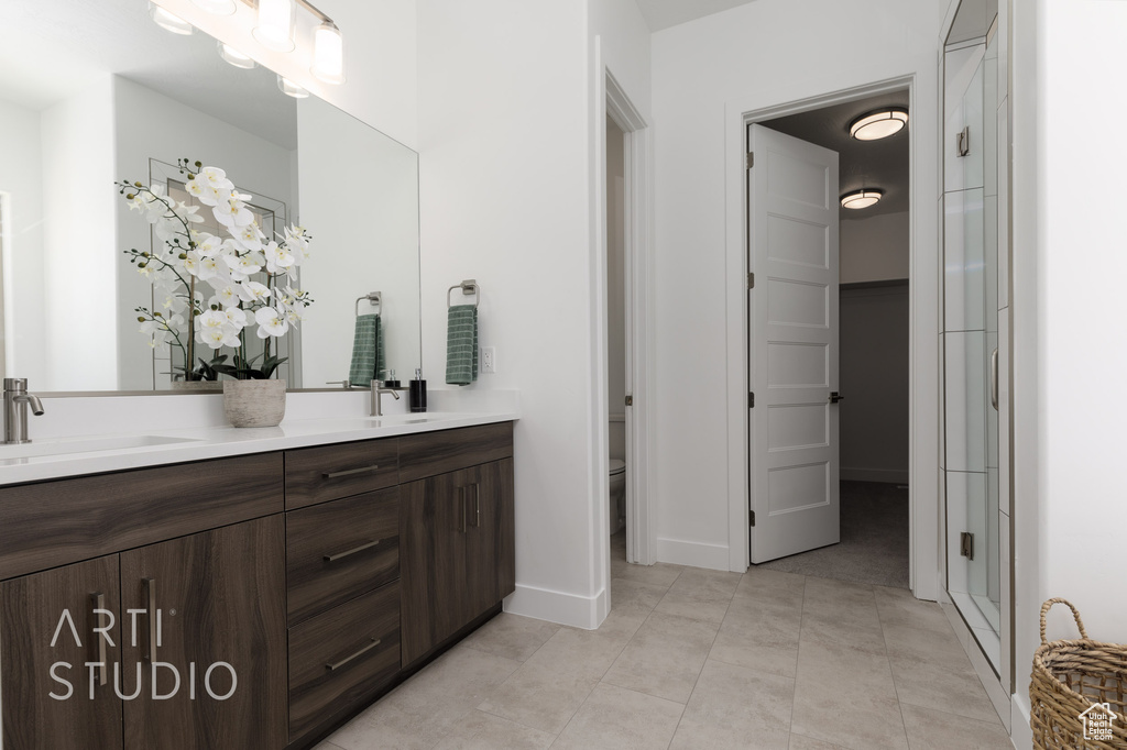 Bathroom with tile patterned flooring, vanity, toilet, and an enclosed shower