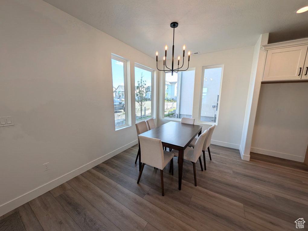 Dining area featuring an inviting chandelier and dark hardwood / wood-style flooring